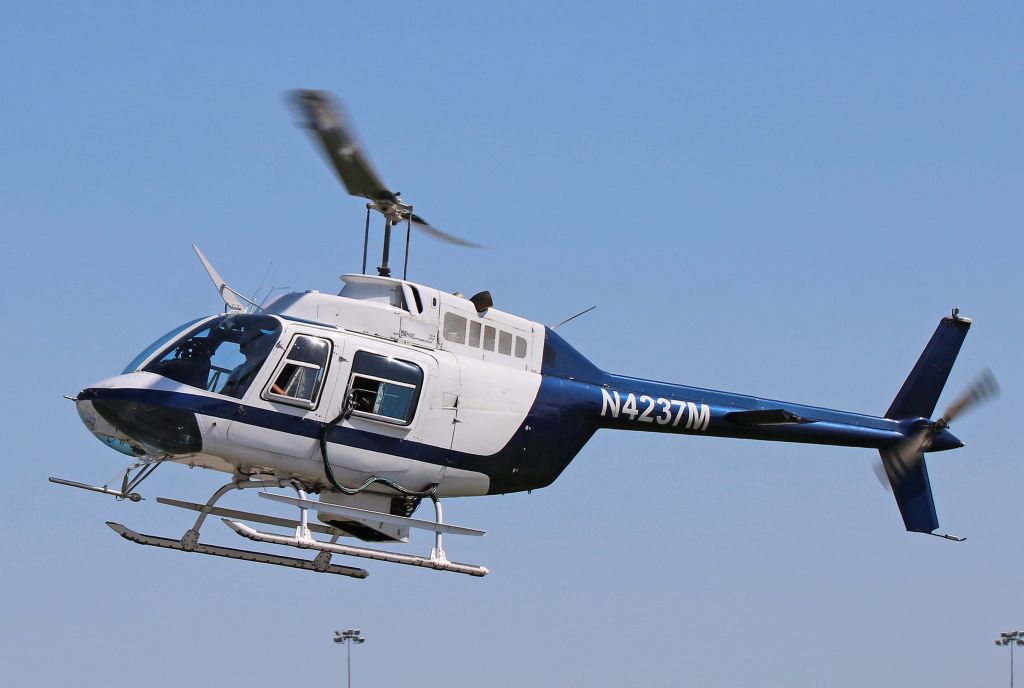 Bell 206 JetRange helicopter flying seen from the left